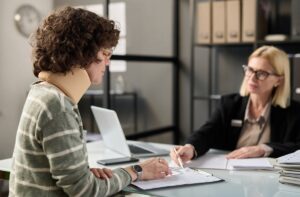 A woman in a neck brace speaking to a lawyer