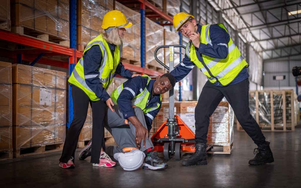 Two workers assisting an injured coworker