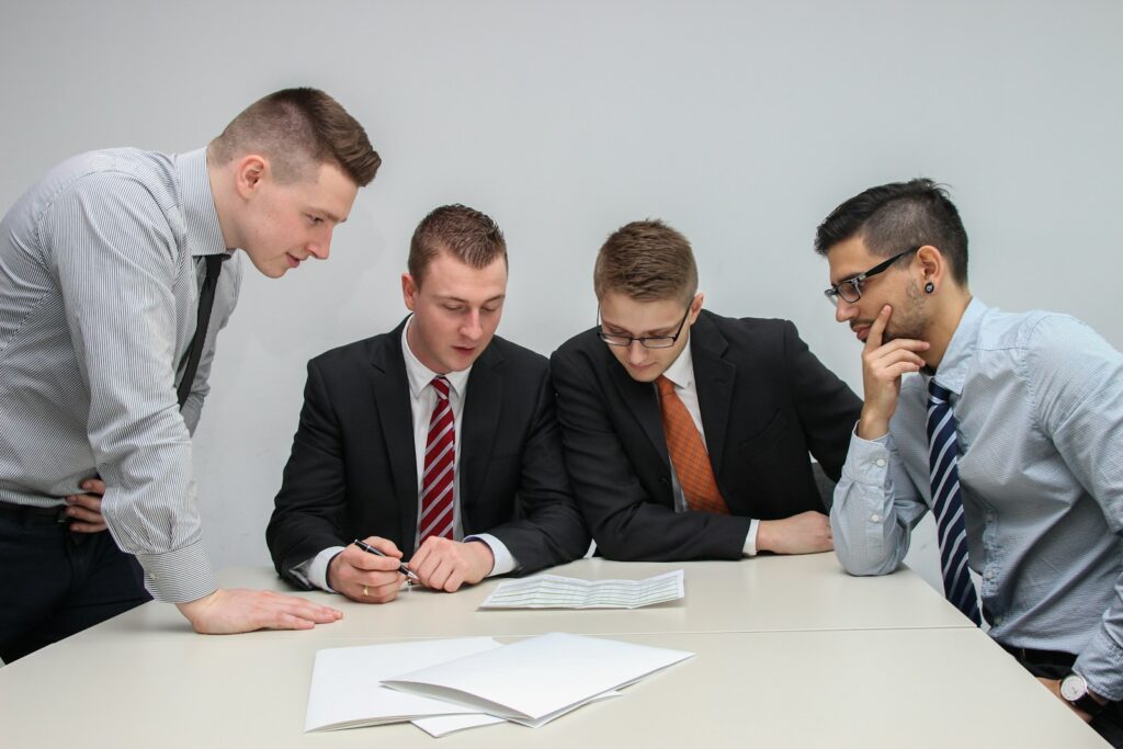four men looking to the paper on table,abogado de accidentes