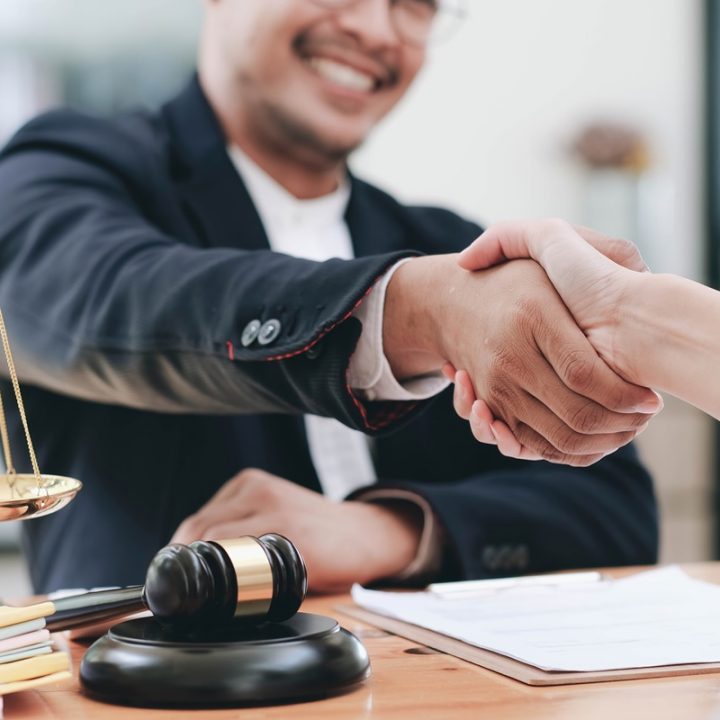 Businessman shaking hands to seal a deal with his partner lawyers or attorneys discussing a contract agreement.